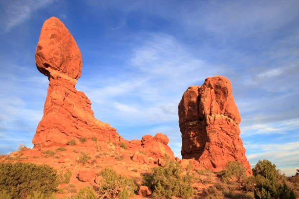 sonnenuntergangsglühen am balanced rock, arches nationalpark - usa arches national park balanced rock colorado plateau stock-fotos und bilder