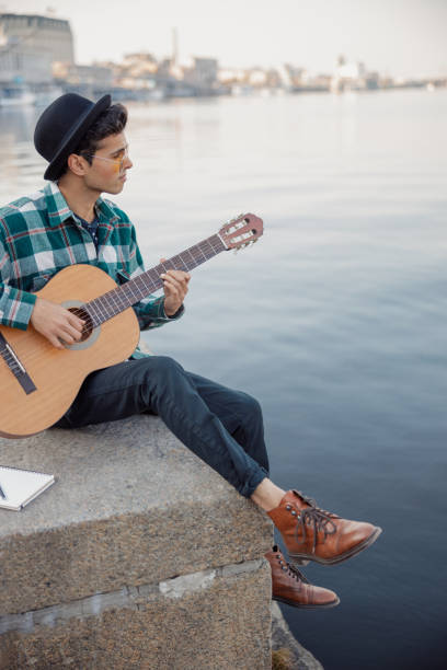 istock Young guitarist is looking to the river 1194191696