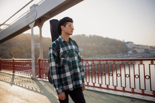 istock Male musician standing with guitar while looking away 1194191701