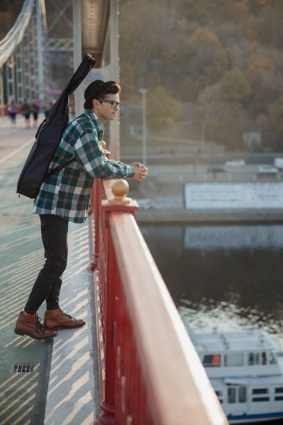 istock Guitarist standing and looking on river outdoors 1194191708