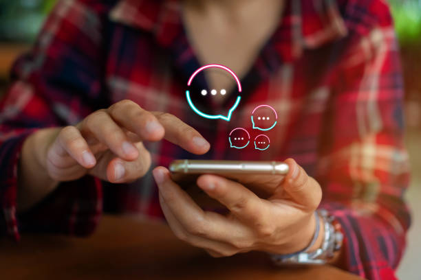 istock People hand using smartphone typing, chatting or text  messages in chat icons pop up. Social media maketing technology concept. Vintage soft color tone background. 1194191972
