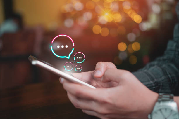 istock People hand using smartphone typing, chatting or text  messages in chat icons pop up. Social media maketing technology concept. Vintage soft color tone background. 1194191987
