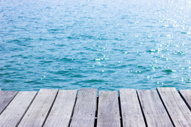istock wooden table top with blue sea background. 1194195913