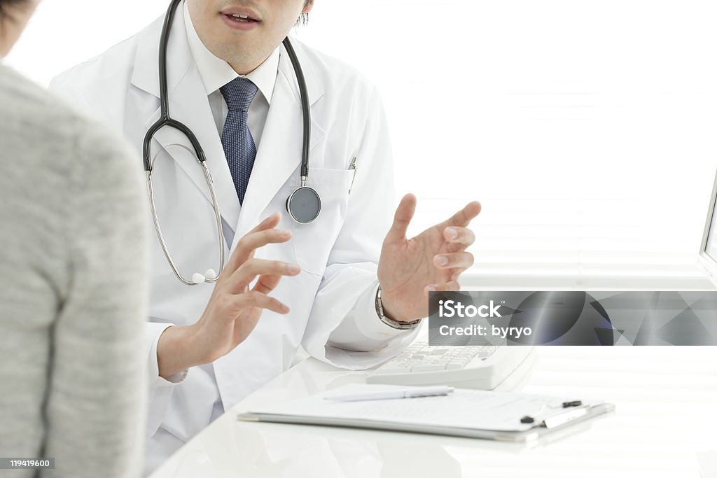 Doctor explaining something to a patient Doctor who explains to patient Adult Stock Photo