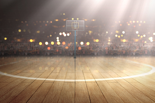 Basketball court with wooden floor and tribune over blurred lights background