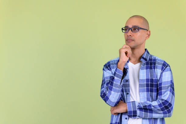 istock Handsome bald hipster man thinking and looking up 1194197870