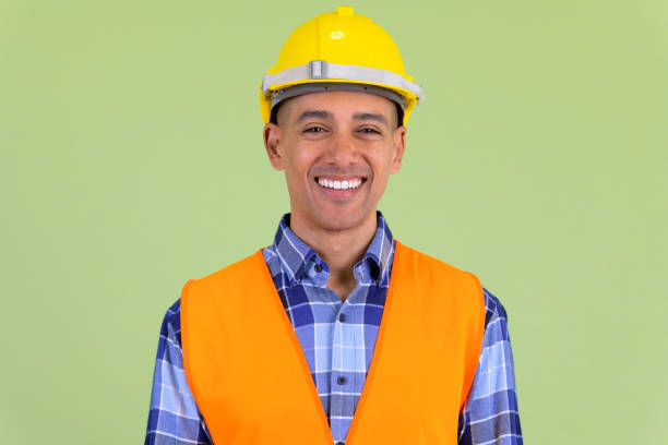 Studio shot of handsome multi ethnic man construction worker against colored background