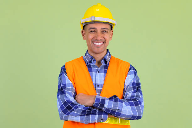 istock Happy multi ethnic man construction worker smiling with arms crossed 1194198104