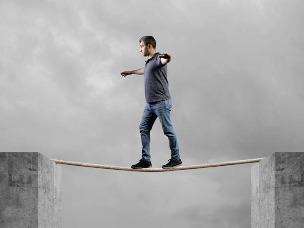 istock Young man on rope balancing with sky 1194200229