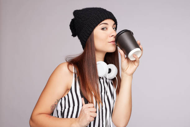 istock Pretty young woman drinks take away coffee indoors 1194201374