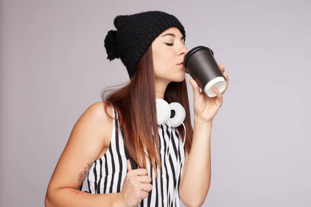 istock Pretty young woman drinks take away coffee indoors 1194201375