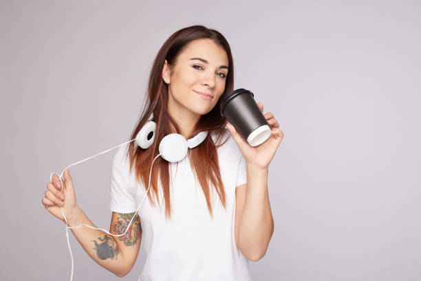 istock Pretty young woman drinks take away coffee indoors 1194201413