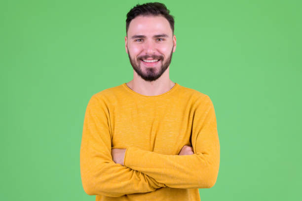 istock Happy young handsome bearded man smiling with arms crossed 1194202314