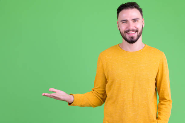 istock Happy young handsome bearded man showing something 1194202346