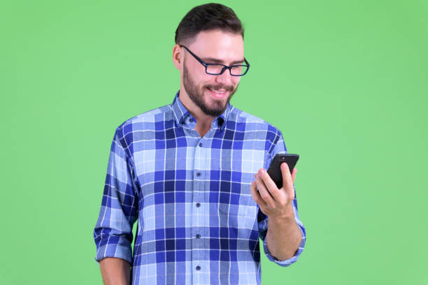 istock Happy young handsome bearded hipster man using phone 1194202353