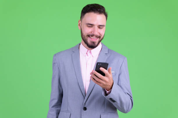istock Happy young handsome bearded businessman using phone 1194202393