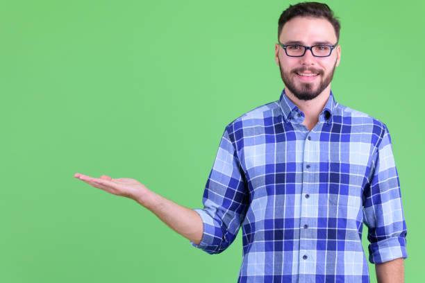 istock Happy young bearded hipster man showing something 1194202406