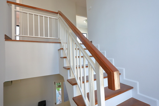 brown wooden stair with white steel balustrade and hardwood handrail banister in modern residential house