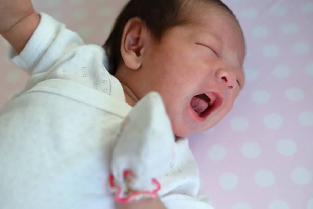 istock cute newborn baby cry on bed 1194207125
