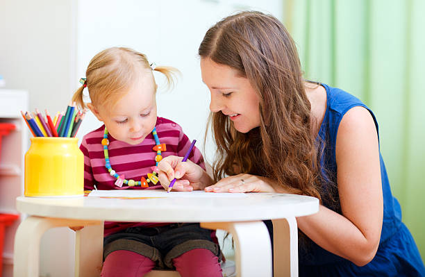 istock Mother and daughter drawing at a kids table 119420758