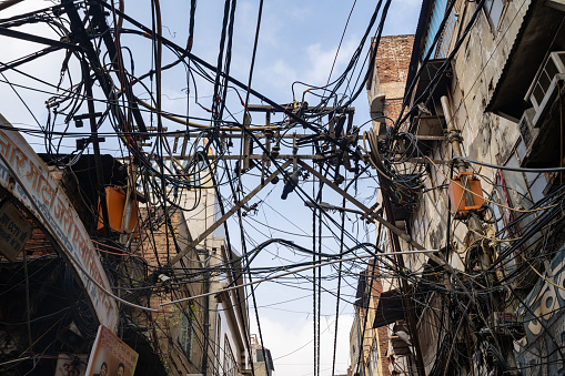 Delhi, India - December 14, 2019: Mess of electrical power line wires on the streets of Old Delhi