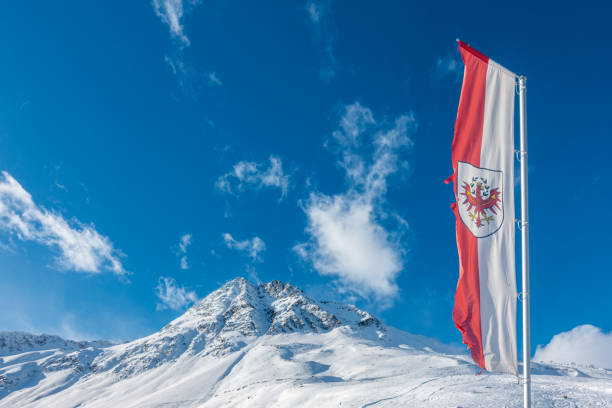 in front of the snow-covered mountains in the Zillertal in Austria an Austrian flag is flying in front of the snow-covered mountains in the Zillertal in Austria an Austrian flag is flying neustift im stubaital stock pictures, royalty-free photos & images
