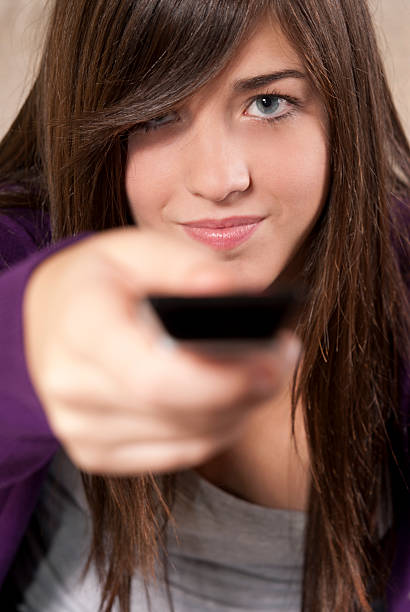 istock Young woman with remote control sitting on sofa close-up 119421684