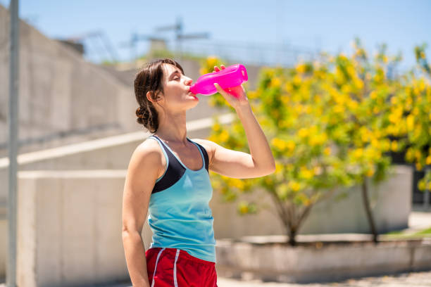istock Female athlete drinking water after running 1194220824