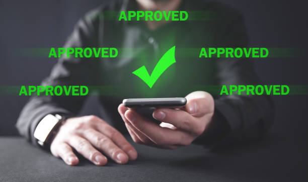 istock Businessman holding smartphone with a check mark. Approved 1194223349