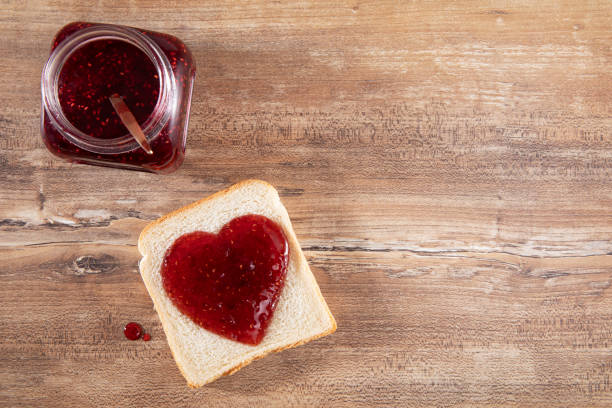 heart shaped raspberry jam on brown wooden table - raspberry heart shape gelatin dessert valentines day imagens e fotografias de stock