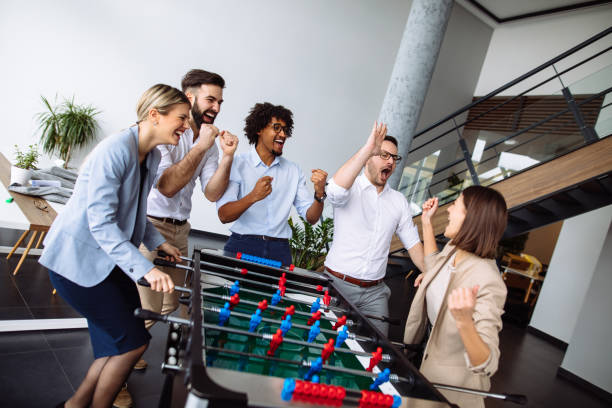 istock Happy young office workers playing table football 1194226303