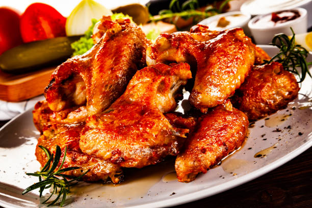 istock Barbecue chicken wings and vegetables on wooden table 1194226519