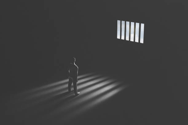 jail window light in a completely dark prison cell illuminated guilty man serie of images representing a business man in silhouette walking trough different shaped door in concrete wall prisoner photos stock pictures, royalty-free photos & images