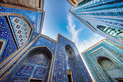 Shah-i-Zinda Mausoleum. ornamental Mosaiq Tile Ritual Building Iwans and Entrance Gates from the 9th-14th century at the famous Shahi Zinda - Shohizinda Necropolis Mausoleum from below against the sky. Ultra Wide Angle Architecture Shot. Samarkand, Silk Road, Uzbekistan, Central Asia