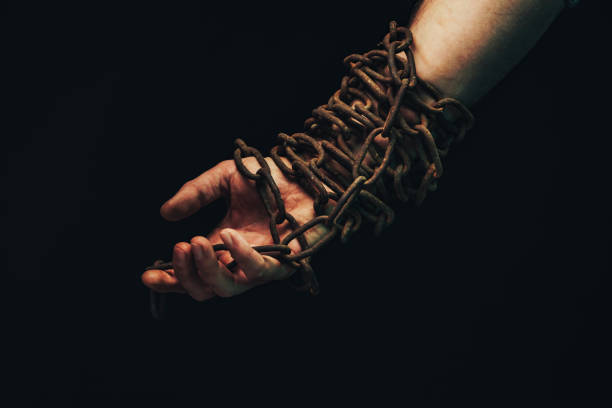 istock Human hand are chained in chains isolated on black background. 1194232991