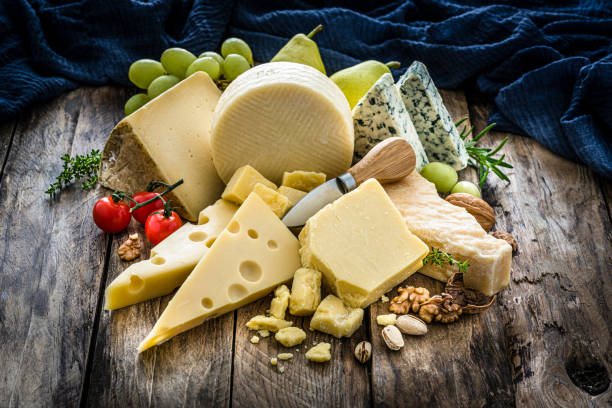 selezione formaggi su tavolo rustico in legno - cheese platter foto e immagini stock