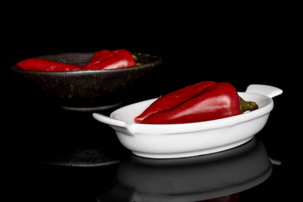 Hot pickled pepper isolated on black glass