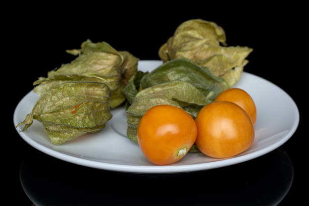 physalis arancione fresco isolato su vetro nero - antioxidant medicine closed close to foto e immagini stock