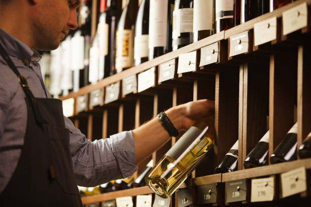 istock Thoughtful expert in winemaking on background of shelves with wine. 1194238897