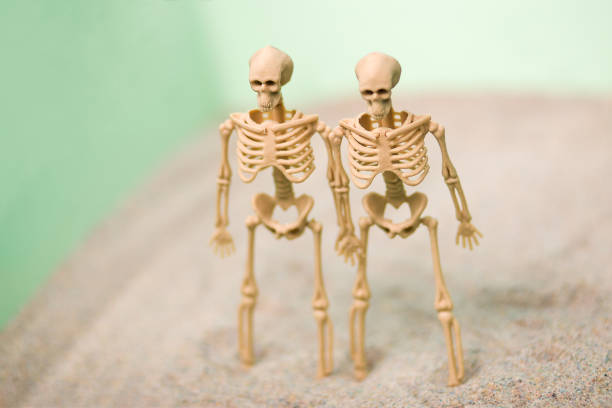 istock skeleton figure lies in the sand 1194240577
