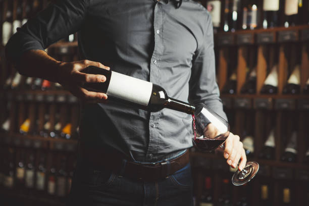 kelner wlewając czerwone wino do kieliszka do wina. - wine decanter red restaurant zdjęcia i obrazy z banku zdjęć