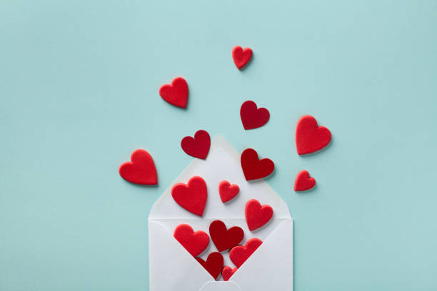 istock Valentine day greeting concept. Envelope and red hearts on blue background top view. Flat lay. 1194243670
