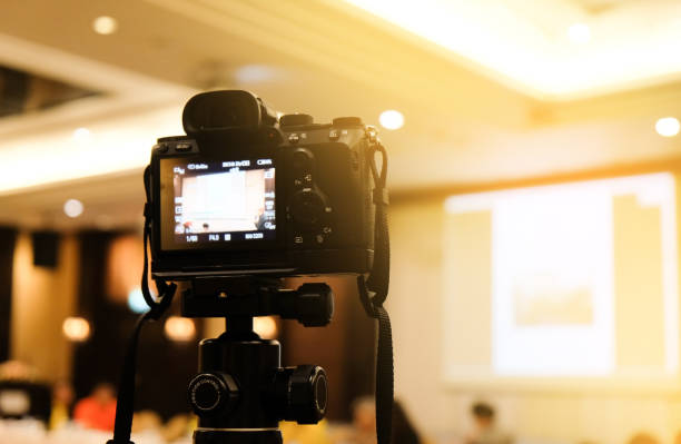 istock camera in business conference room recording participants and speaker echnology transformation of mirrorless camera. 1194246500