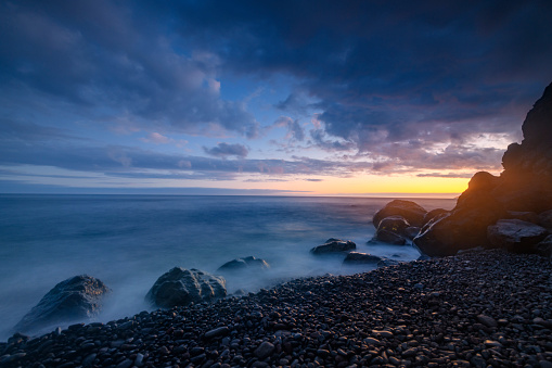 Sunset at Cristo Rei Beach or Praia do Garajau on Madeira island during summer. Long exposure image.