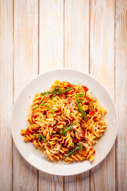 pasta mit schweinefleisch, sauce und gemüse auf farbverlauf hintergrund - pasta directly above fusilli food stock-fotos und bilder