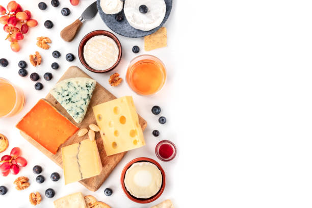 istock Cheese board background, a flatlay top shot on white with copy space. Blue cheese, red Leicester, Emmental, goat cheese, Brie and others with wine, fruits, nuts and almonds, with a place for text 1194248982