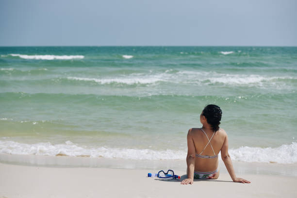 Stunning and Content Mature Woman on the Beach with Curly Hair, Golden-Toned Skin