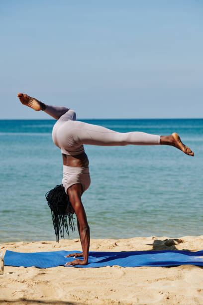 istock Slim young woman practicing handstand 1194249892