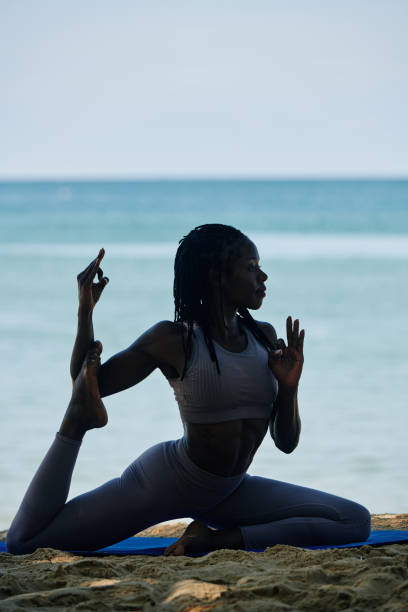 istock Black woman doing swan pose 1194249897