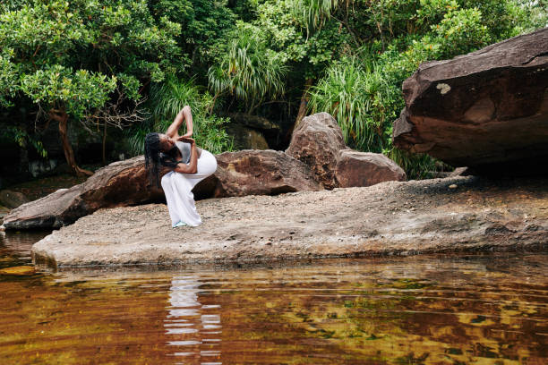istock Woman exercising in forest by the creek 1194249924